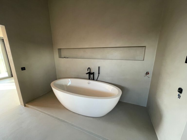 Modernes Badezimmer mit freistehender Badewanne in Betonoptik