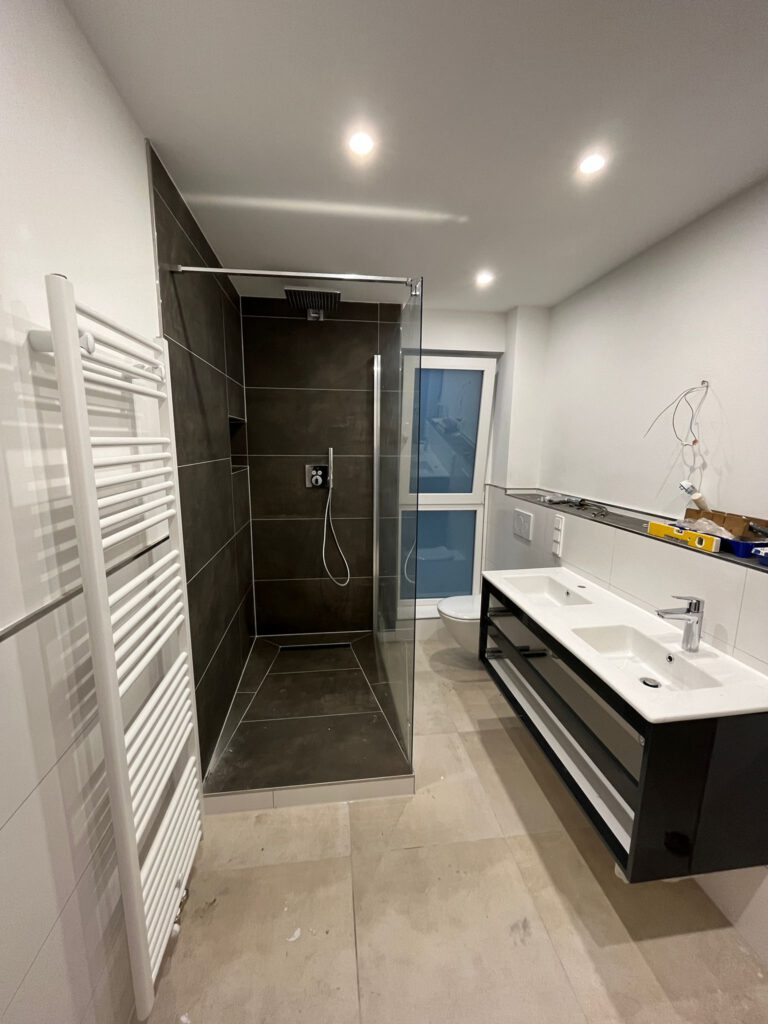 Badezimmer mit Walk-in-Dusche, Doppelwaschtisch und Handtuchheizkörper